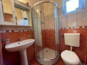 y baño con aseo, lavabo y ducha. en Apartments Marković, en Budva