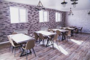 a row of tables and chairs in a room with a brick wall at Гостевой дом Villa Aila in Mineralnye Vody