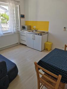 uma cozinha com uma mesa e um lavatório num quarto em Apartment Buzolic em Hvar