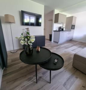 a living room with a table with flowers on it at Appartement Rakké Kiefernweg Winterberg in Winterberg