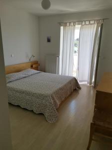 um quarto com uma cama e uma grande janela em Apartment Buzolic em Hvar
