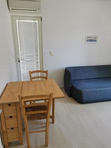 uma sala de estar com uma mesa e um sofá azul em Apartment Buzolic em Hvar