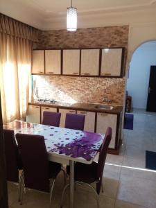 a kitchen with a table and some purple chairs at الفارس الوسيم للشقق الفندقيه in Amman