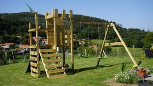 einen Holzspielplatz mit einer Leiter und einer Schaukel in der Unterkunft Casa Madrazo con piscina y parrillas in Praves