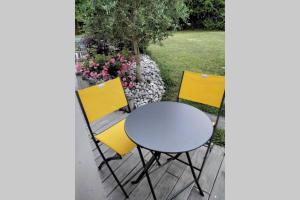 a table and two yellow chairs on a patio at le studio du fou in Mortagne-sur-Sèvre
