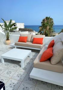 a patio with couches and a table and the ocean at Roof Top Pied dans l'Eau Panoramic View, 80 meters from Seaside in Hammamet