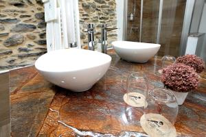 a bathroom with a sink and wine glasses on a counter at Alformil in Bragança