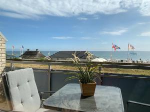a table and chairs on a balcony with a view of the ocean at Haus Fischerstrand - Fewo Boje in Dahme