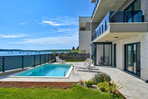 a house with a swimming pool next to a body of water at Pure in Medulin