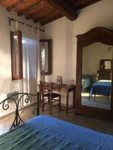 Schlafzimmer mit einem Bett, einem Spiegel und einem Schreibtisch in der Unterkunft Agriturismo Fontevecchia in Vetulonia