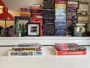 ein Haufen Bücher, die auf einem Regal liegen in der Unterkunft Central London Charming Camden Split Level Home in London