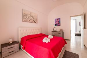 Un dormitorio con una cama roja con dos ositos de peluche. en Palazzo Fiordaliso - Puglia Mia Apartments, en Monopoli