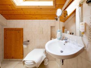 a bathroom with a sink and a toilet at Holiday Apartements by Hotel Grüner Baum Feldberg in Feldberg