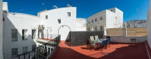 a balcony with a table and chairs on a building at Caminito del Falla III Ha Apartment in Cádiz