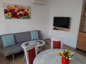 a living room with a couch and a table and a tv at Apartment Luna in Trogir
