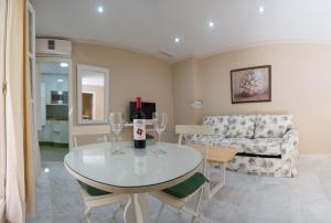 una sala de estar con una mesa y copas de vino en Caminito del Falla B Ha Apartment, en Cádiz