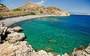 a beach with people swimming in the water at Komi's Pink Paradise 1 in Kómi