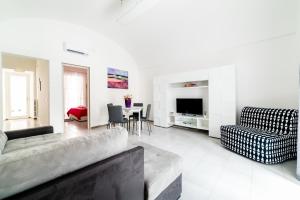 Una sala de estar con un sofá, una silla y una mesa. en Palazzo Fiordaliso - Puglia Mia Apartments, en Monopoli