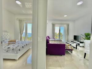 sypialnia z łóżkiem i fioletową kanapą w obiekcie Seaside Apartments Sword w Barze
