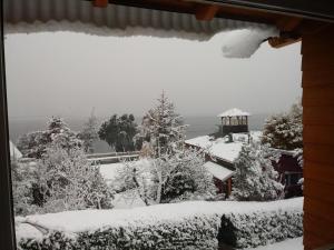 a snow covered window of a house with a gazebo at Andalue in San Carlos de Bariloche