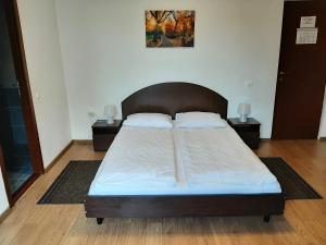 クルジュ・ナポカにあるVila Vandaのベッドルーム(大型ベッド1台、ナイトスタンド2台付)