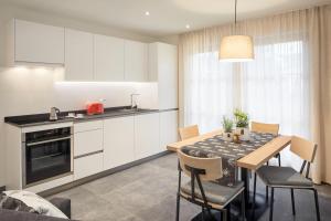 a kitchen and dining room with a table and chairs at daHoam Appartamenti in Rasùn di Sotto