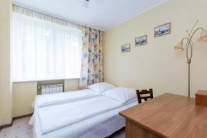 a bedroom with a bed and a desk and a window at Apartament Nadmorski Wyspa Sobieszewska in Gdańsk