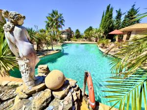 a statue of a woman standing next to a swimming pool at Quinta do Mar - Country & Sea Village in Luz +43 photos