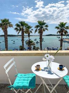 a table and chair with a view of the water at Casa Clementina Rooms vista mare in Porto Cesareo