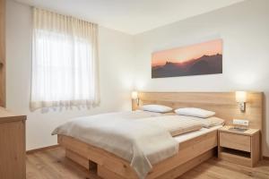 um quarto com uma cama grande e uma janela em daHoam Appartamenti em Rasùn di Sotto