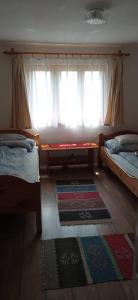 a bedroom with two beds and a window at Hegyi Nyaraló in Sátoraljaújhely +12 photos