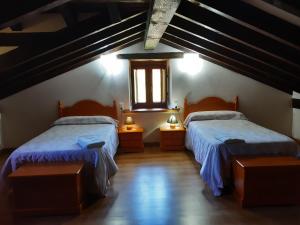 sypialnia z dwoma łóżkami i oknem w obiekcie Casa Santa Leocadia w mieście Tama