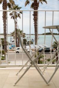 uma cadeira em frente a uma praia com palmeiras em Casa Clementina Rooms vista mare em Porto Cesareo