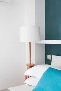 a bedroom with a white bed and a lamp at Casa Clementina Rooms vista mare in Porto Cesareo