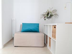 a couch with a blue pillow on it in a room at Casa Clementina Rooms vista mare in Porto Cesareo