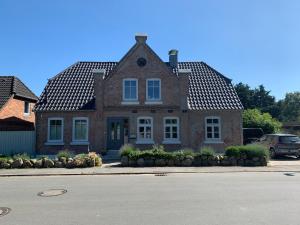 ein Backsteinhaus mit einem schwarzen Dach in der Unterkunft Ferienwohnung Sonnentraum in Bannesdorf