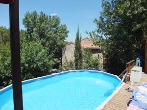 une grande piscine bleue sur une terrasse en bois dans l'établissement Sur la Bonnefooi, à Prades-sur-Vernazobre