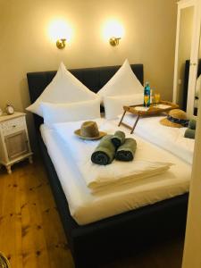 two beds with towels and hats on top of them at Ferienwohnung B im Ferienhaus Antika in Ratzeburg