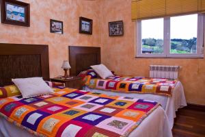 1 dormitorio con 2 camas y 2 ventanas en Tranquilidad en helguera, en Helguera