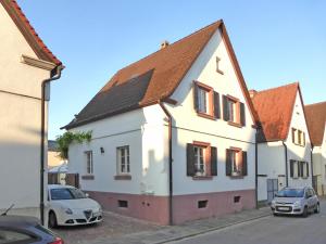 Biały dom z dwoma samochodami zaparkowanymi przed nim w obiekcie Stilvoll Urlaub machen! w mieście Dudenhofen