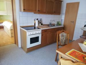 a kitchen with a white stove and a sink at Ferienwohnung Stiem in Dankerode