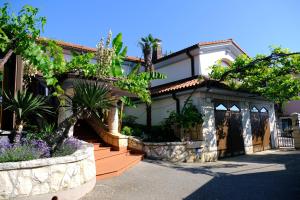 une maison avec une terrasse couverte et un jardin dans l'établissement Villa Monterose, à Malija