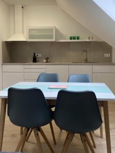 a kitchen with a table and four chairs at Oázis apartmanház in Fertőszentmiklós