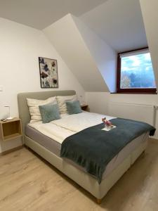 a bedroom with a bed and a window at Oázis apartmanház in Fertőszentmiklós