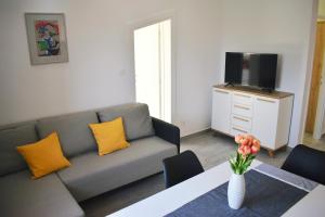 ein Wohnzimmer mit einem Sofa und einem Tisch mit gelben Kissen in der Unterkunft Klikly in Labin