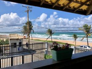 a balcony with a view of the beach and a house at casa praia beira mar praia Flamengo in Salvador
