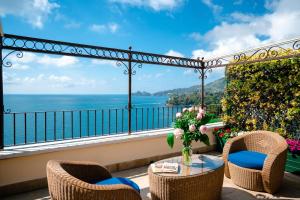 a balcony with chairs and a table with a view of the ocean at Excelsior Palace Portofino Coast in Rapallo