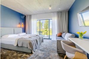 sypialnia z niebieskimi ścianami, łóżkiem i kanapą w obiekcie Kite Marina Sarbsk w mieście Sarbsk