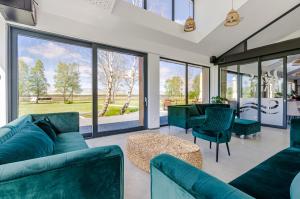 una sala de estar con muebles verdes y ventanas grandes. en Kite Marina Sarbsk en Sarbsk