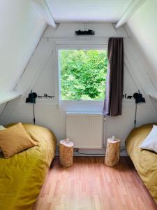 two beds in a small room with a window at La cabane, Durbuy in Durbuy